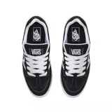 Championes Vans modelo Upland, de diseño urbano con estética skate. Presentan una base de gamuza negra con costuras blancas en contraste y el logo lateral característico de la marca en color blanco. Cuentan con suela de goma blanca y cordones al tono.