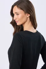 Remera lisa de algodón color blanco, con cuello redondo y botones a tono. Tiene manga larga y un ruedo curvo.