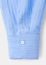 Camisa de manga larga con diseño a rayas en tonos celestes y blancos, cuello camisero y cierre frontal con botones.