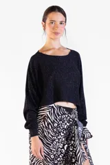 Sweater negro de punto con hilo lurex brillante, escote bote, mangas largas y corte corto tipo crop.