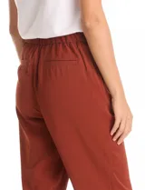 Pantalon de corte relajado color naranja, con cintura plana en el frente y elástica en la parte posterior. Presenta pierna sutilmente entallada, bolsillos laterales diagonales y bolsillos traseros simulados.