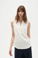 Musculosa de poliéster color blanco, con cuello en V y diseño holgado sin mangas.