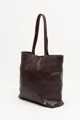 Cartera tote negra de símil cuero con diseño texturizado de parches y asas largas.