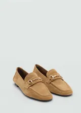 Mocasines de cuero color marrón claro, con punta fina y detalle de hebilla metálica dorada.