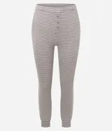 Pijama de dos piezas compuesto por una blusa de manga larga con cuello redondo y un pantalón con cintura elástica. Presenta un diseño de rayas horizontales en tonos gris y blanco.