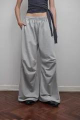 Pantalón de jogging gris melange, corte amplio, con cintura elástica, bolsillos laterales y pinzas en las rodillas.
