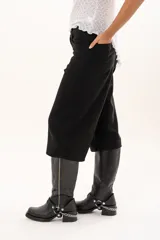 Bermuda de corte amplio y tiro alto en color negro, con cierre frontal de botón y bolsillos laterales.