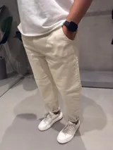 Jean de corte slouchy en color beige, confeccionado en denim de algodón. Presenta un diseño de tiro medio con ajuste holgado en la cadera y muslos, estrechándose hacia los tobillos.