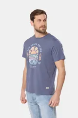 Remera de cuello redondo y manga corta, confeccionada en tejido de algodón con acabado jaspeado. Presenta un estampado frontal con temática de surf y estilo retro en tonos pasteles.