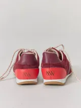 Championes de cuero en tonos bordó y rojo, con diseño de paneles combinados en gamuza y cuero texturizado. Presentan suela blanca con base dentada color caramelo y cordones jaspeados.