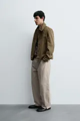 Cazadora regular fit color verde militar, confeccionada en tejido efecto ante. Presenta cuello solapa, manga larga, bolsillos de vivo en la cadera y cierre frontal de botonadura.