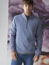Fleece de algodón color azul, con cuello alto y cierre frontal parcial. Diseño de manga larga con puños y ruedo acanalados.