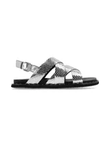 Sandalia de cuero plateado con textura de reptil, diseño de tiras cruzadas en el empeine y ajuste mediante hebilla metálica en el talón. Cuenta con una suela plana de goma negra con detalle de tachas decorativas en el borde.