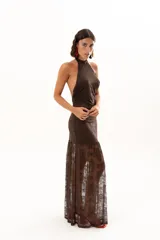 Vestido largo de encaje color chocolate, con escote halter y diseño ajustado en el torso que se abre en una falda con transparencia en el ruedo.