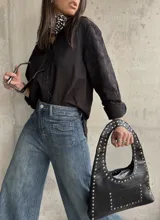 Camisa negra con bordados florales en las mangas, cuello clásico y cierre frontal con botones.