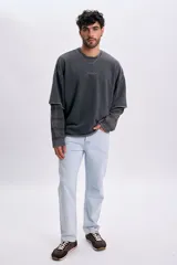 Pantalón de jean azul claro de corte recto y clásico, con bolsillos laterales y traseros y cierre frontal con botón y cremallera.