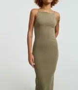 Vestido midi de corte ajustado, confeccionado en tejido de algodón con elastano. Presenta escote recto, breteles finos y una abertura en la parte trasera del ruedo.