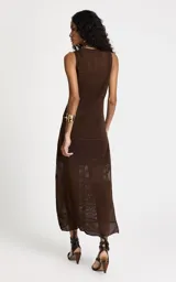 Vestido midi de tejido de punto color chocolate, con cuello redondo, sin mangas y silueta ajustada. Presenta un diseño de tramas caladas alternadas y una abertura lateral en el dobladillo.