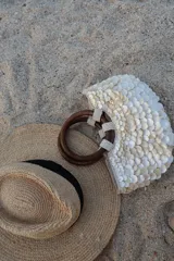 Bolso de mano con forma de media luna cubierto de perlas sintéticas. Tiene asas circulares de madera y detalles de cuentas en la unión con el cuerpo del bolso.