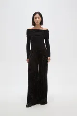 Pantalon de corte ancho y tiro alto, confeccionado en tela de terciopelo con acabado brillante. Presenta cintura elástica y pinzas frontales que aportan volumen y caída fluida a la prenda.