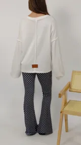 Sweater de punto color blanco, con cuello redondo, mangas largas holgadas y costuras expuestas que le aportan un detalle distintivo.