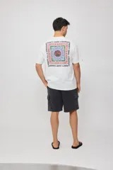 Remera de algodón color celeste pálido con cuello redondo y manga corta. Presenta un pequeño estampado frontal de un sol estilizado en tonos naranja y azul.