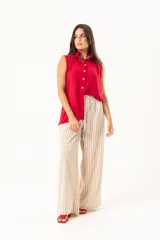 Camisa roja sin mangas con cuello mao adornado con un volado y cierre frontal con botones.