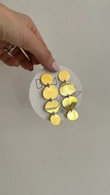 Aros colgantes con forma de discos de bronce y alpaca.