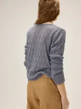 Buzo de tejido en lurex con escote en V, manga larga y silueta relajada, con un brillo sutil y textura tramada.