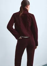 Chaqueta entallada de terciopelo bordó, de manga larga con puños abotonados, cuello camisero, cierre frontal con botones y detalle de costuras visibles.