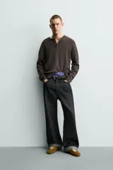 Jersey relaxed fit de punto acanalado color marrón oscuro, con cuello redondo tipo panadera y cierre frontal de tres botones. Tiene manga larga y efecto lavado.