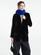 Blazer negro de terciopelo con solapa, bolsillos delanteros con tachas y corte holgado.