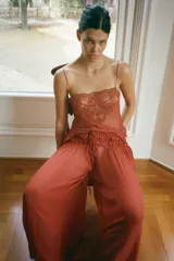 Pantalón semitransparente de pernera ancha, tiro medio y cintura elástica ajustable con lazadas, confeccionado en 100% viscosa.