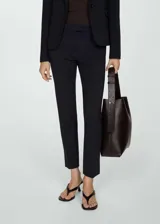 Pantalón de vestir tiro medio confeccionado en punto roma, con diseño recto, bolsillos laterales y bolsillos de ribete en la parte posterior, cierre de cremallera y gancho con trabillas en la cintura.