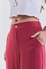 Pantalón sastrero de color bordó, tiro alto, corte wide leg y bolsillos laterales.