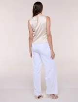 Blusa de satén color negro, de corte fluido, con escote asimétrico y un aro metálico decorativo en el hombro.