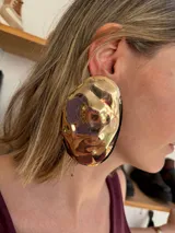 Aros grandes de metal dorado con textura irregular.