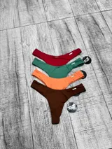 Parte inferior de bikini tipo colaless, de tiro bajo y cobertura mínima, disponible en varios colores sólidos.