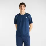 Remera deportiva New Balance Tournament de color azul marino, con cuello redondo, mangas raglán y detalles de ribete blanco en las costuras de los hombros. Cuenta con el logotipo de la marca impreso en el pecho.