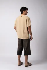 Remera de corte regular confeccionada en una mezcla de rayón y lino con textura entramada. Presenta cuello redondo, mangas cortas y un diseño de inspiración rústica y liviana.