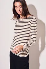 Remera de algodón color crema con rayas horizontales negras, cuello bote y mangas largas.