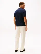 Chomba de punto Tommy Hilfiger color azul marino, con estructura de panal de abeja, cuello tipo polo sin botones y manga corta.