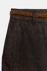 Pantalón chino de tiro bajo color marrón oscuro, con pernera recta y bajo con vuelta. Incluye un cinturón trenzado delgado de color marrón claro. Cuenta con bolsillos delanteros y cierre frontal con cremallera y botón.