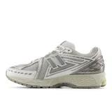 Championes urbanos New Balance modelo 1906R, con diseño inspirado en el running de los años 2000. Presentan una combinación de malla técnica y detalles sintéticos en tonos gris y blanco, con acentos en verde neón en la suela y el talón. Incorporan tecnología de amortiguación N-ergy, entresuela ACTEVA LITE y talón con ABZORB SBS para mayor estabilidad y confort.