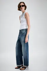 Jeans de tiro medio con diseño de cinco bolsillos, pernera holgada y bajo con vuelta. Cierre frontal con cremallera y botón.