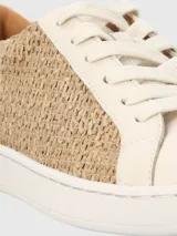 Zapatillas urbanas Hush Puppies modelo Merano, con diseño que combina cuero sintético en color blanco y paneles laterales de tejido tipo rafia en tono natural. Presentan suela de goma blanca y cierre mediante cordones.