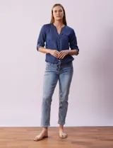 Blusa celeste de tencel, marca Alex & Parker. Cuello a la base, escote en V y abertura central con botones. Delantera con bolsillos. Largo de manga regulable con presilla y botón. Terminación de ruedo con nudo.