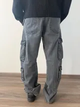 Pantalón tipo jean cargo de corte baggy, color celeste claro, con múltiples bolsillos laterales y cierre frontal.
