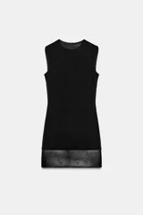 Vestido mini negro sin mangas, de cuello redondo, con detalle de tejido efecto piel combinado a tono en el bajo. Cuenta con forro interior y cierre en la espalda con cremallera oculta.