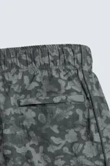 Bañador de hombre de tejido técnico, color gris oscuro con estampado abstracto en tonos más claros. Presenta cintura elástica ajustable con cordón, bolsillos laterales y un bolsillo trasero de plastrón.